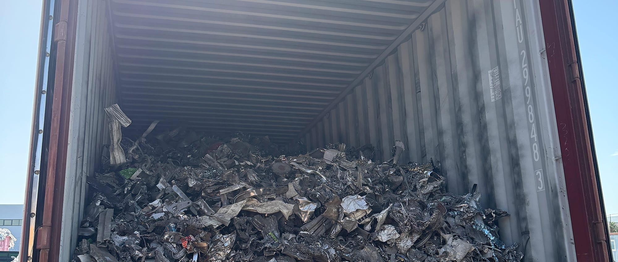 A shipping container part-loaded with mixed non-ferrous scrap, ready for export